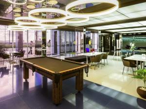 a pool table in a room with tables and chairs at ibis Styles Confins Aeroporto in Lagoa Santa