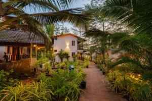 uma casa com muitas plantas na frente em The Riverside em Mandrem