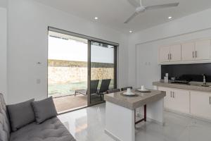 a kitchen and living room with a couch and a table at Safiro Suites Guayabitos Apartments - Adults Only in Rincon de Guayabitos