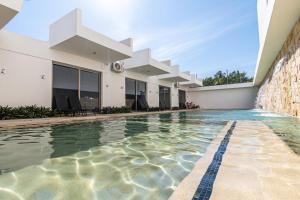 a swimming pool in front of a building at Safiro Suites Guayabitos Apartments - Adults Only in Rincon de Guayabitos