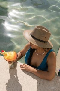 a young woman wearing a hat sitting in a pool at Safiro Suites Guayabitos Apartments - Adults Only in Rincon de Guayabitos