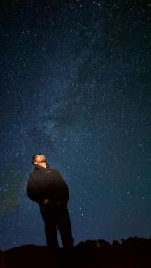 a man looking up at the starry sky at night at The Royal Roast in Shoja