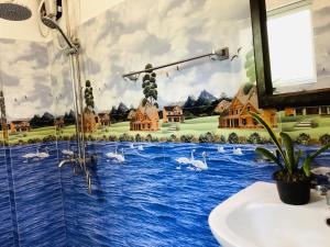 a bathroom with a mural of swans on the wall at Nila Villa & Homestay in Galle