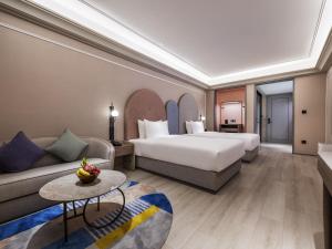 une chambre d'hôtel avec un lit et un canapé dans l'établissement Mercure Jingjiang Downtown, à Jingjiang 39 autres photos