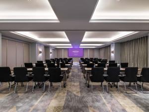 une salle de conférence avec des rangées de tables et de chaises dans l'établissement Mercure Jingjiang Downtown, à Jingjiang