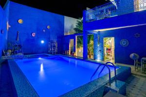a large swimming pool with blue lighting in a house at Villa Andaloussya, Majorel Host in Aït Ourir +35 photos
