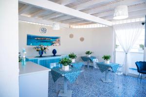 a white room with blue tables and chairs at B&B PLAZA in Lampedusa