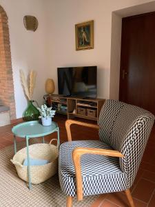 a living room with a chair and a table at Holiday home Garetto Basso in Chianni