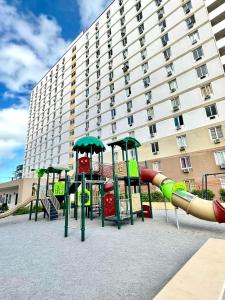einen Spielplatz vor einem großen Gebäude in der Unterkunft ART Dreamplace 1BR Studio Pool WiFi Netflix in Suba