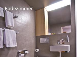 ein Badezimmer mit einem Waschbecken, einem Spiegel und Handtüchern in der Unterkunft Kartause Ittingen in Warth