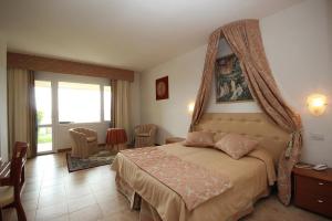 a bedroom with a bed with a canopy at Relax Hotel Acquaviva - Tuscany Hills in Lucciana