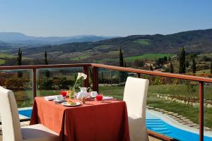 a table with a plate of food on a balcony at Relax Hotel Acquaviva - Tuscany Hills in Lucciana