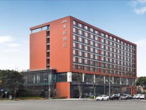 a red brick building with cars parked in front of it at Mercure Chengdu Shuangliu in Chengdu