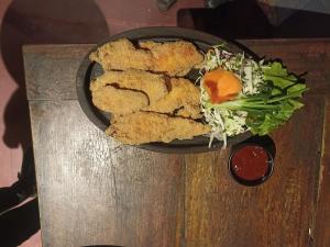 a plate of food with a salad on a table at Noah's Yacht Farm in Siolim