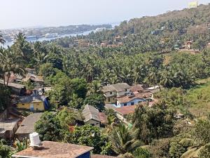 a village on a hill with palm trees at Noah's Yacht Farm in Siolim