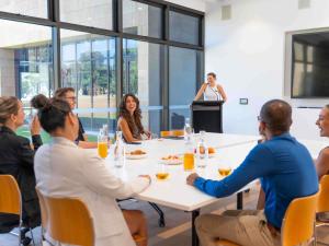 un grupo de personas sentadas alrededor de una mesa con un micrófono en Wonil Hotel Perth - Handwritten Collection, en Perth
