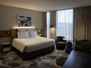 une chambre d'hôtel avec un lit et deux chaises dans l'établissement Pullman Sydney Penrith, à Penrith