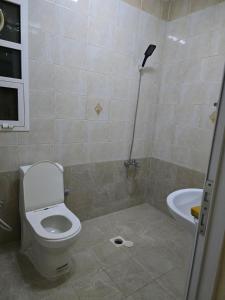 ein Badezimmer mit Toilette, Waschbecken und Dusche in der Unterkunft Mozna Hostel in Muscat + 8 Fotos