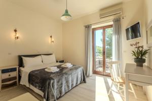 a bedroom with a bed and a desk and a window at Vardia Hotel in Kardamili +68 photos