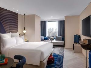 een hotelkamer met een groot bed en een woonkamer bij TRIBE Living Bangkok Sukhumvit 39 by AccorHotels in Bangkok