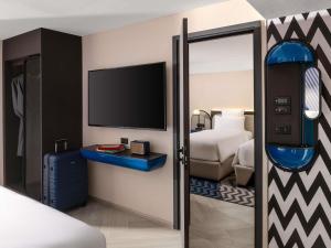 een hotelkamer met een bed en een tv bij TRIBE Living Bangkok Sukhumvit 39 by AccorHotels in Bangkok