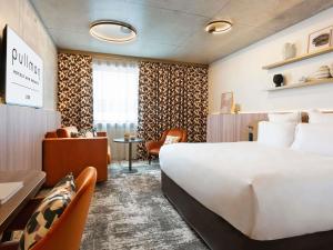 um quarto de hotel com uma cama grande e uma escrivaninha em Pullman Lyon em Lyon