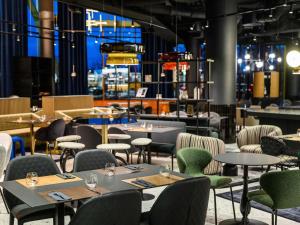 Un comedor con mesas y sillas y un escritorio. en TRIBE Budapest Stadium, en Budapest