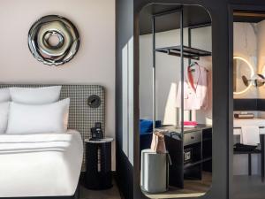 a bedroom with a white bed and a mirror at TRIBE Budapest Stadium in Budapest +118 photos