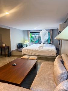 a hotel room with a bed and a couch at Pridi cozy home with good location Type A in Bangkok +86 photos