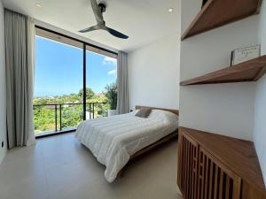 ein Schlafzimmer mit einem Bett und einem großen Fenster in der Unterkunft Villa Vega 3BR Sea View Near Beach in Ungasan + 40 Fotos