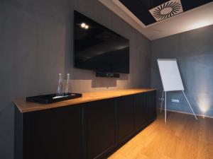 a kitchen with a counter with a flat screen tv at greet hotel Cernay Mulhouse in Cernay