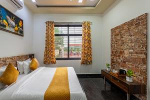 une chambre avec un lit et un mur de briques dans l'établissement Gtn Aranya Villas, à Eklingji 50 autres photos