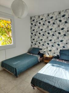 滨海阿热莱斯Charmante Villa de plain pied dans quartier calme的房间里有两张床，墙上挂着帽子。