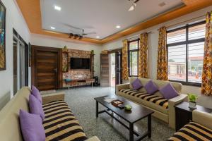 un salon avec deux canapés et une télévision dans l'établissement Gtn Aranya Villas, à Eklingji