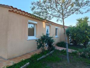 滨海阿热莱斯Charmante Villa de plain pied dans quartier calme的一栋房子前面有一棵树