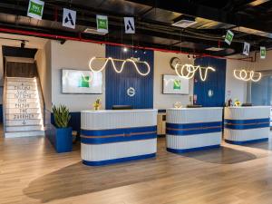 a restaurant with blue and white counters in a room at Ibis Styles El Malecon Guayaquil in Guayaquil