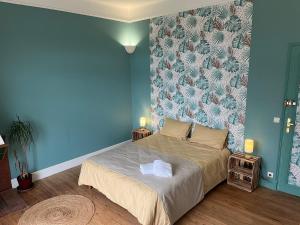 une chambre avec un lit avec un mur bleu dans l'établissement Gîte de Monplaisir, Pomarez, à Pomarez