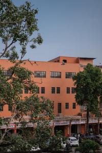 an orange building with trees in front of it at Abode Jaipur in Jaipur