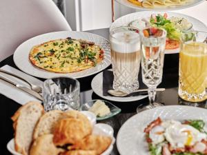 a table topped with plates of food and drinks at The Crown Krakow Center - Handwritten Collection ACCOR in Krakow