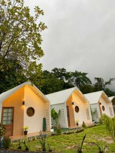 a row of white buildings with trees in the background at Chamin Longbeach Resort 
