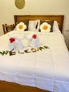 a bed with white sheets with flowers on it at Chamin Longbeach Resort 