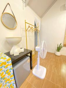 a bathroom with a fan and a mirror at Chamin Longbeach Resort 