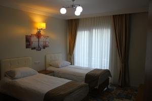een hotelkamer met 2 bedden en een raam bij Deveci Hotel in Mut