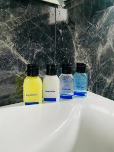 un groupe de quatre bouteilles assises au-dessus d'un évier dans l'établissement Infinity Winter Resort, à Nuwara Eliya