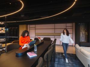 Dos mujeres sentadas en una mesa en una habitación en TRIBE Lyon Croix Rousse, en Lyon