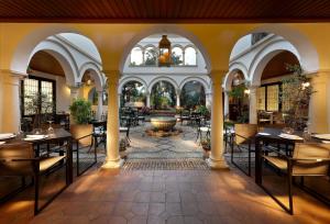 a restaurant with tables and chairs and a fountain at Eurostars Conquistador in Córdoba