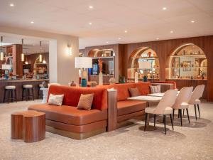 un salon avec un canapé, une table et des chaises dans l'établissement Novotel Orléans Centre Gare, à Orléans