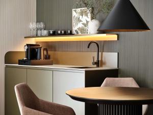 a kitchen with a table and two chairs and a sink at Mövenpick Resort & Spa Karpacz in Karpacz +211 photos