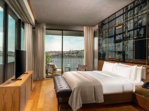 a hotel room with a bed and a large window at Rixos Tersane Istanbul in Istanbul +198 photos