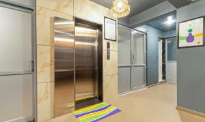 Treebo Liyan Orchid, Hsr Layout في بانغالور: ممر به مصعد معدني مع شريحة ملونة
